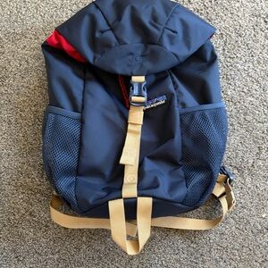 Patagonia navy backpack with tan straps and red accent